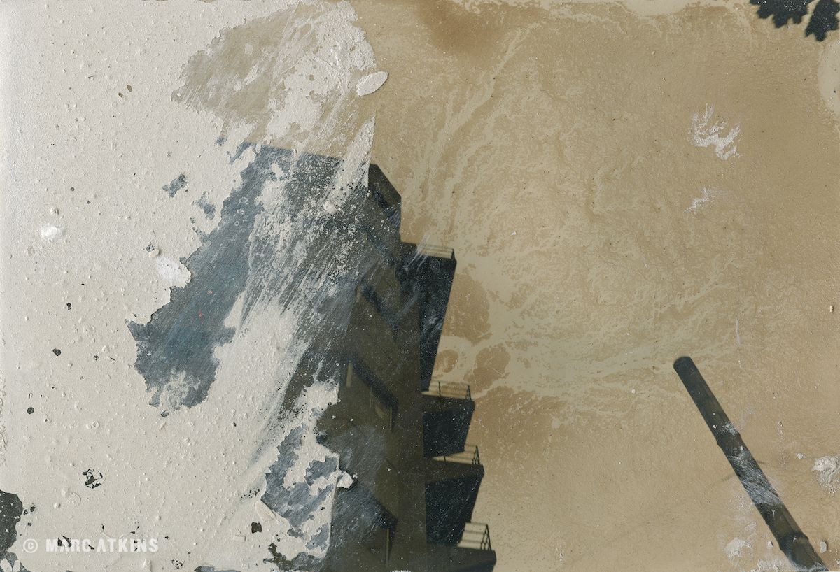 Pale abstract surface with dark vertical forms and textured marks