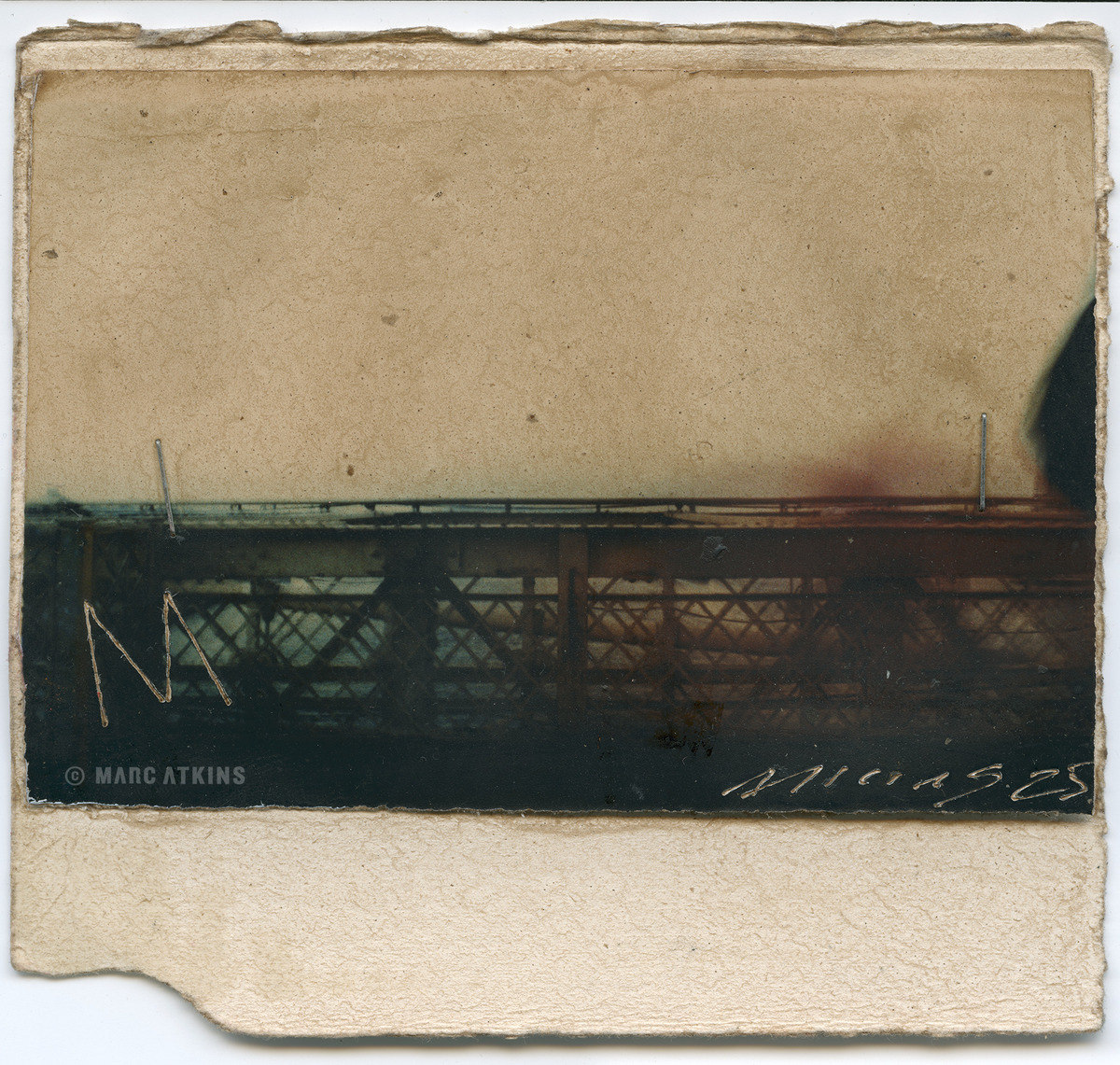 Dark steel bridge across the lower edge of a worn, pale print