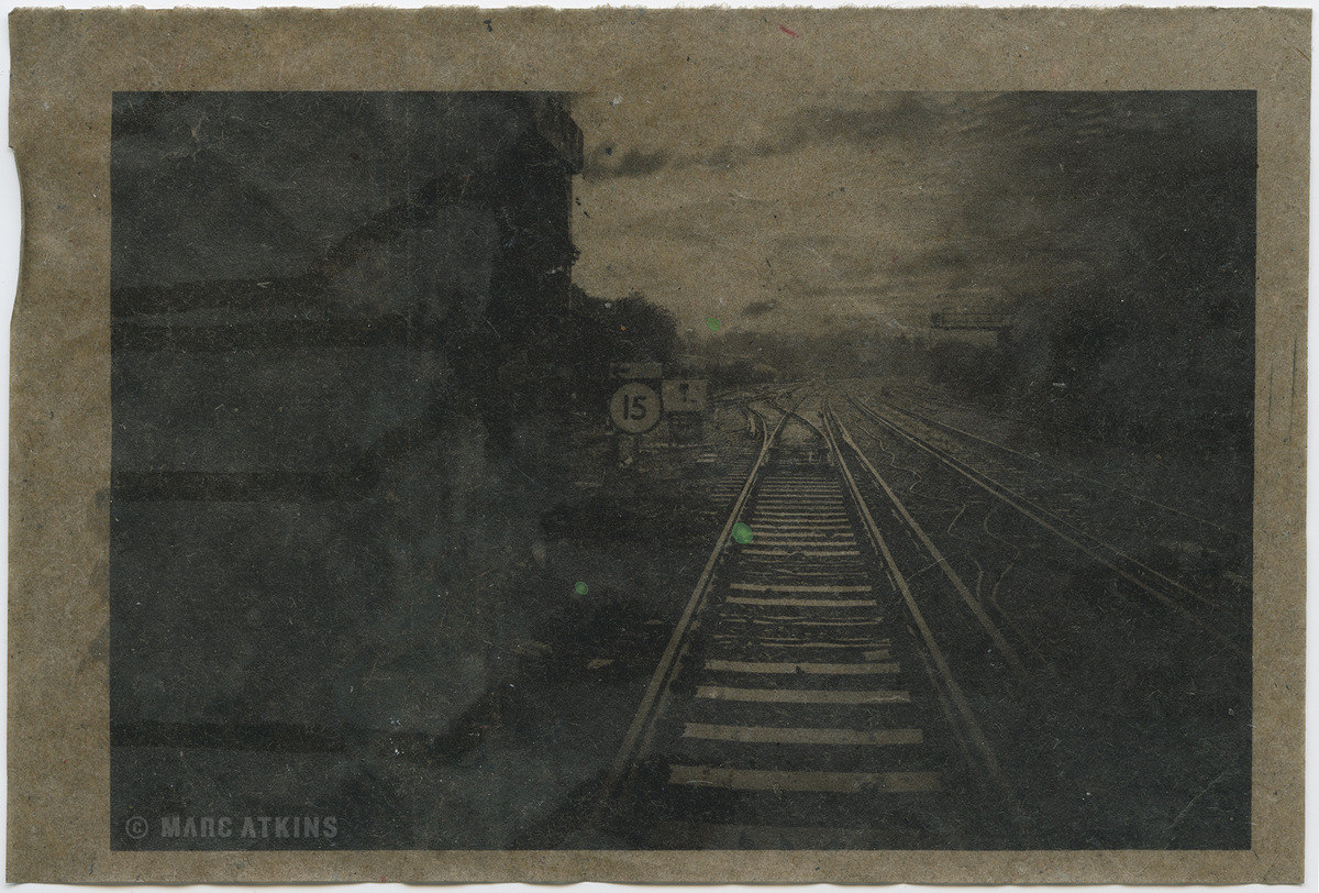 Dark railway tracks receding into a misty landscape