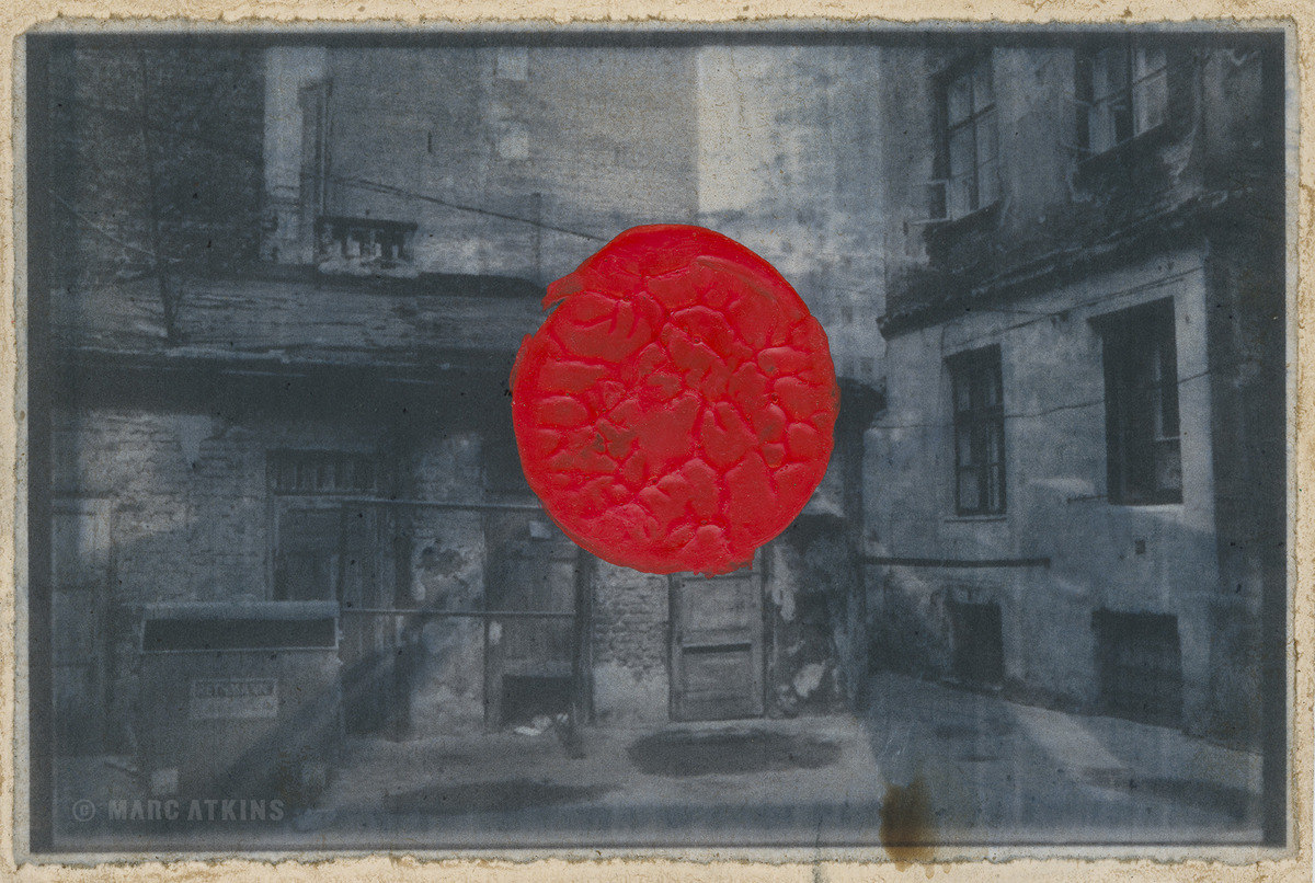 Black-and-white back street overlaid with a red circular mark